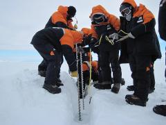 Scientists drill into sea ice to measure its thickness.