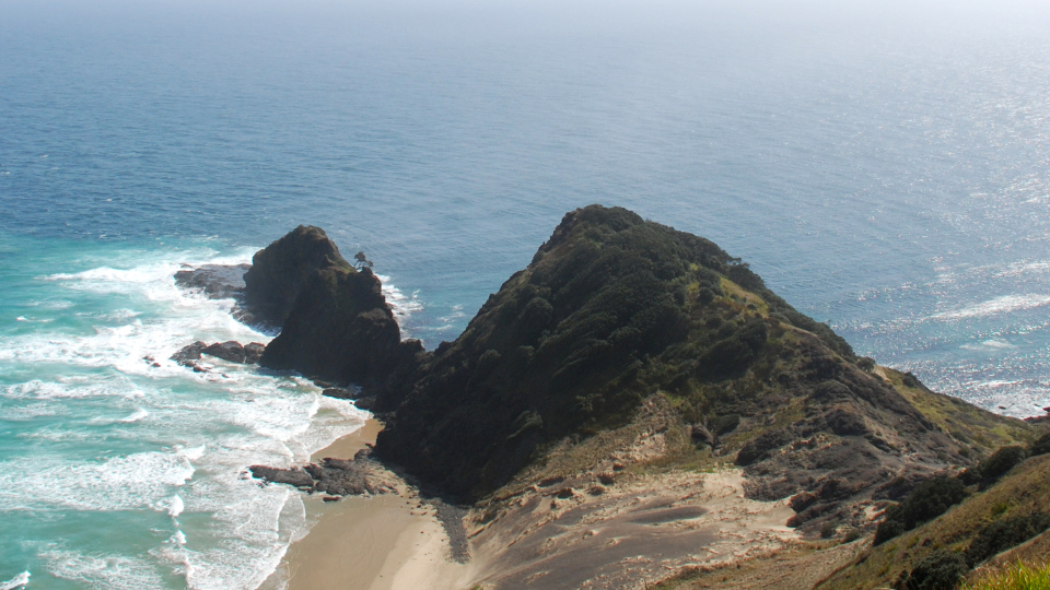 Te Rerenga Wairua (the spirit’s leap), at Cape Rēinga. Image: Phillip Capper from Wellington, New Zealand, CC BY 2.0 <https://creativecommons.org/licenses/by/2.0>, via Wikimedia Commons.
