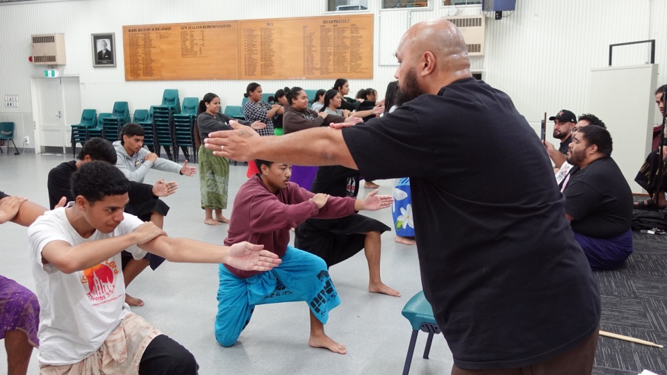 Image: A community mentor guiding students with their performance.