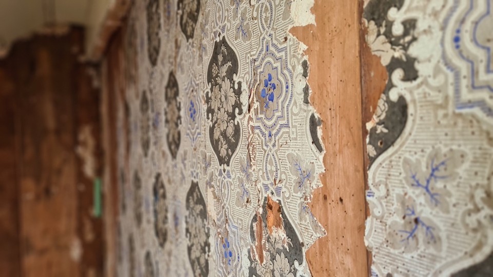 Over time there have been several layers of wallpaper added to the mission house walls. Image: LEARNZ.